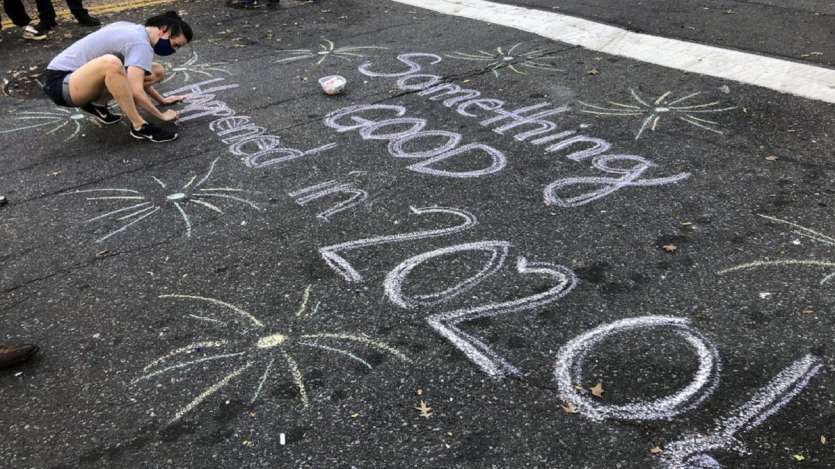 Jolin Polasek draws a sign in chalk on a street in Harlem after former vice president and Democratic presidential candidate Joe Biden was announced as the winner over Pres. Donald Trump to become the 46th president of the United States, in New York. 